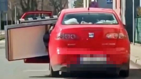 Otwarte drzwi auta, wystająca kanapa. Ryzykowna jazda nagrana, zgłoszona i zakończona mandatem. WIDEO