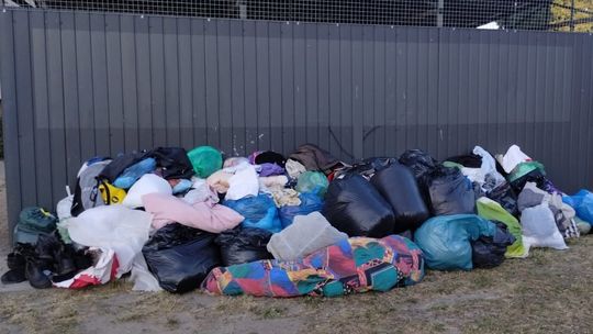Worki pełne odzieży i tekstyliów lądują pod wiatami śmietnikowymi